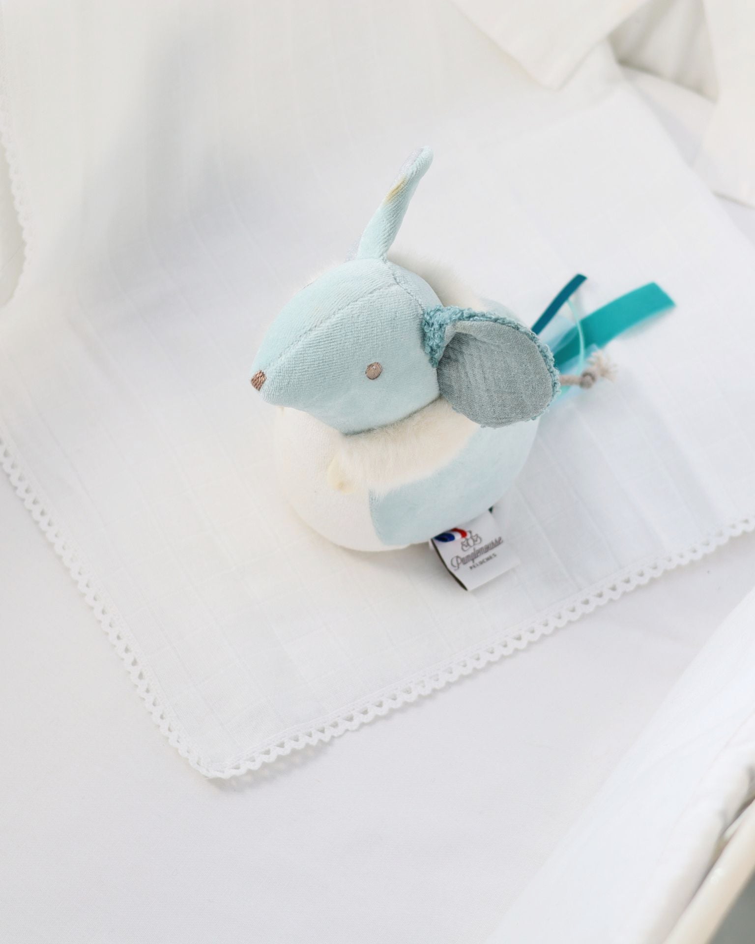 Plush toy with a tag on a white blanket